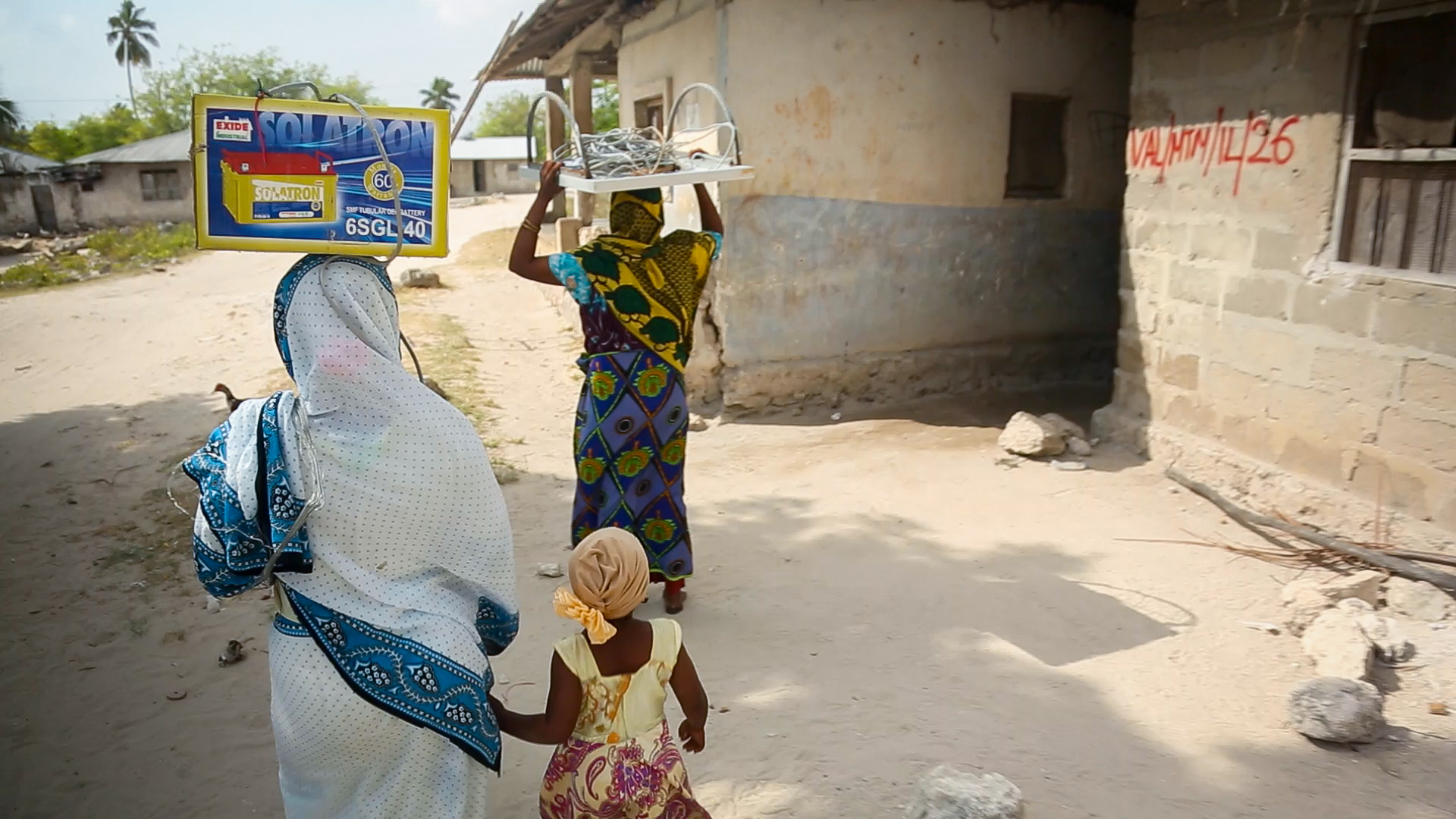 Two Solar Mamas carry equipment from their village workshop to a home in Matemwe where they will be installing a new system. A new center being built on the island will train a new batch of 24 female solar engineers, each of whom who will install and main