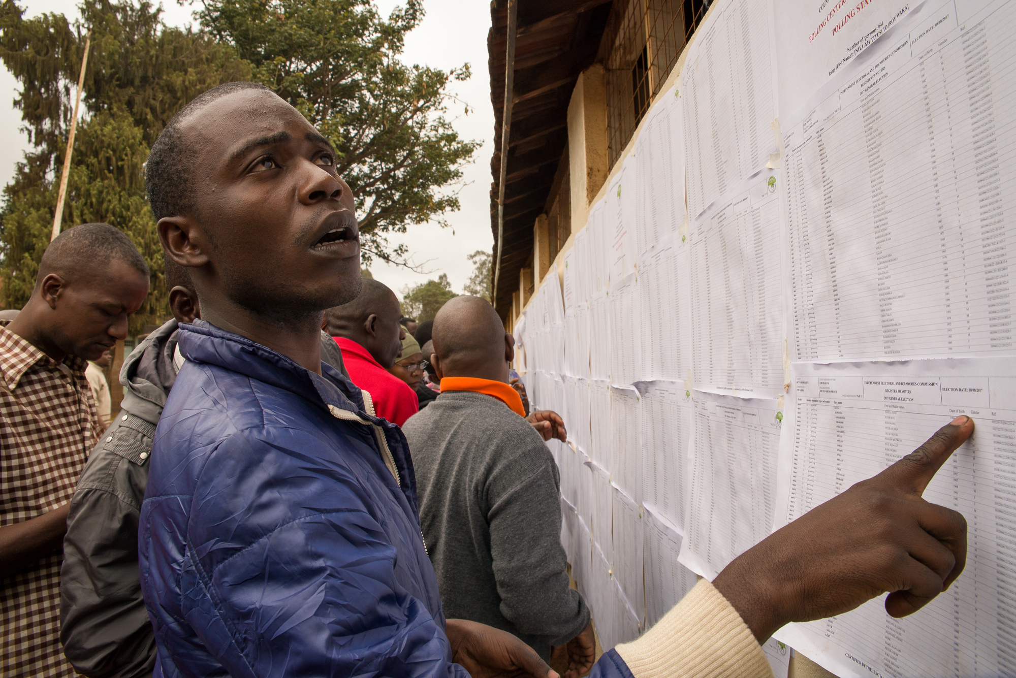 A man from an informal settlement in Nairobi searches for his name on a voter registration list at Kibera Primary School. Some voters were unable to locate their names on the registrar, forcing them to contact election officials for assistance. A man from an informal settlement in Nairobi searches for his name on a voter registration list at Kibera Primary School. Some voters were unable to locate their names on the registrar, forcing them to contact election officials for assistance.