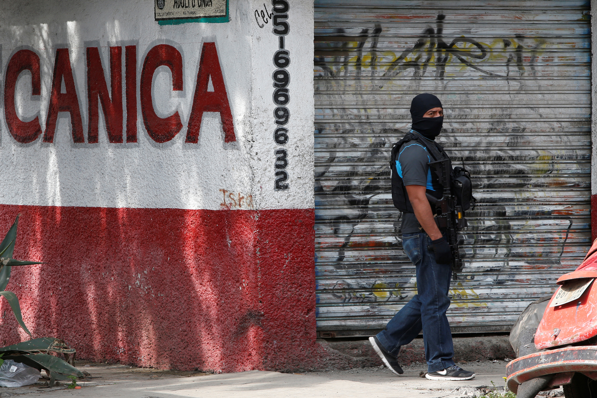 A Mexican police special agent guards an area after a shootout between gang members and the Mexican army in Mexico City. A Mexican police special agent guards an area after a shootout between gang members and the Mexican army in Mexico City.