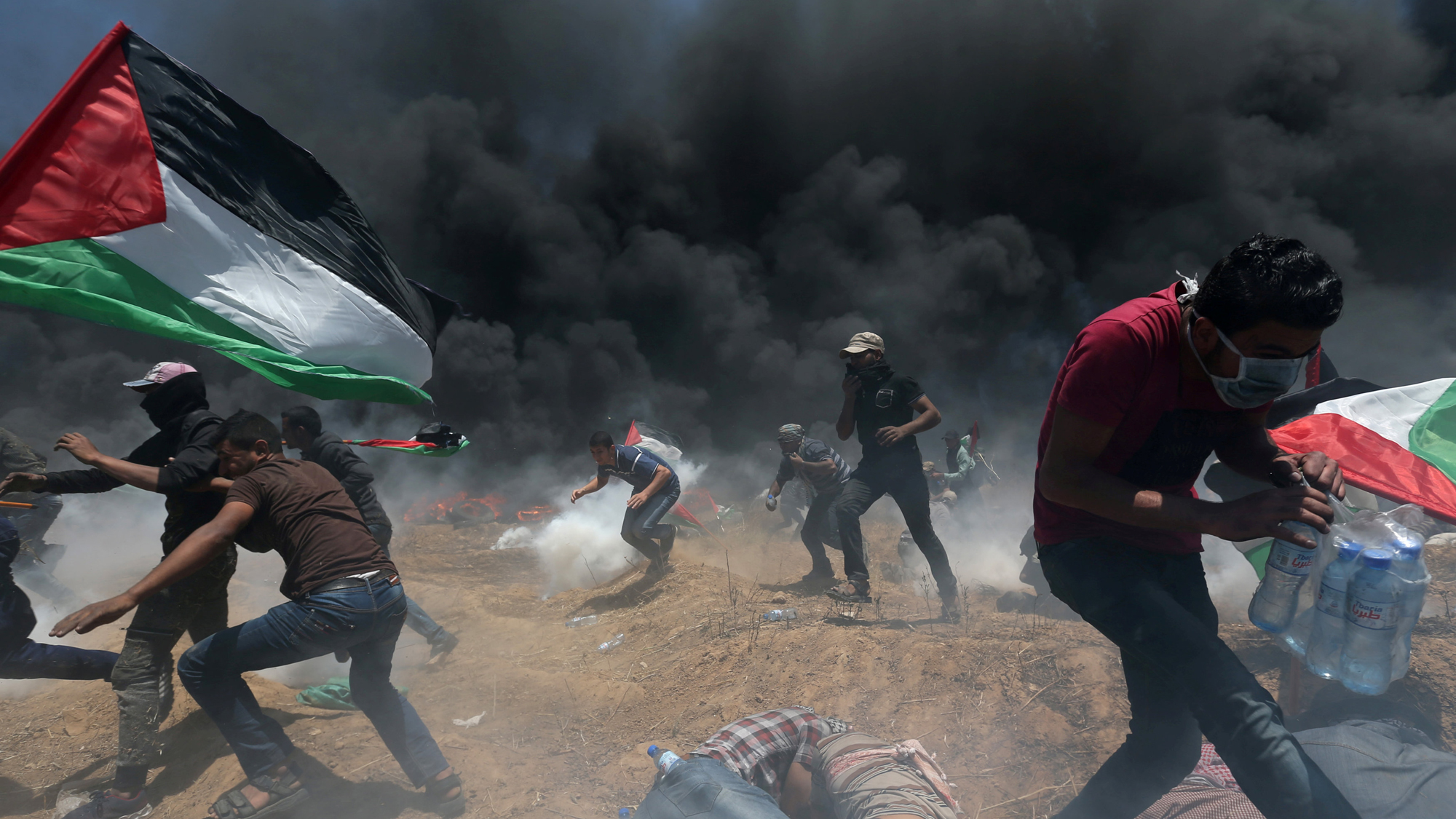 Palestinian demonstrators run for cover from Israeli fire and tear gas during a protest against US embassy move to Jerusalem, May 14, 2018. Palestinian demonstrators run for cover from Israeli fire and tear gas during a protest against US embassy move to Jerusalem, May 14, 2018.