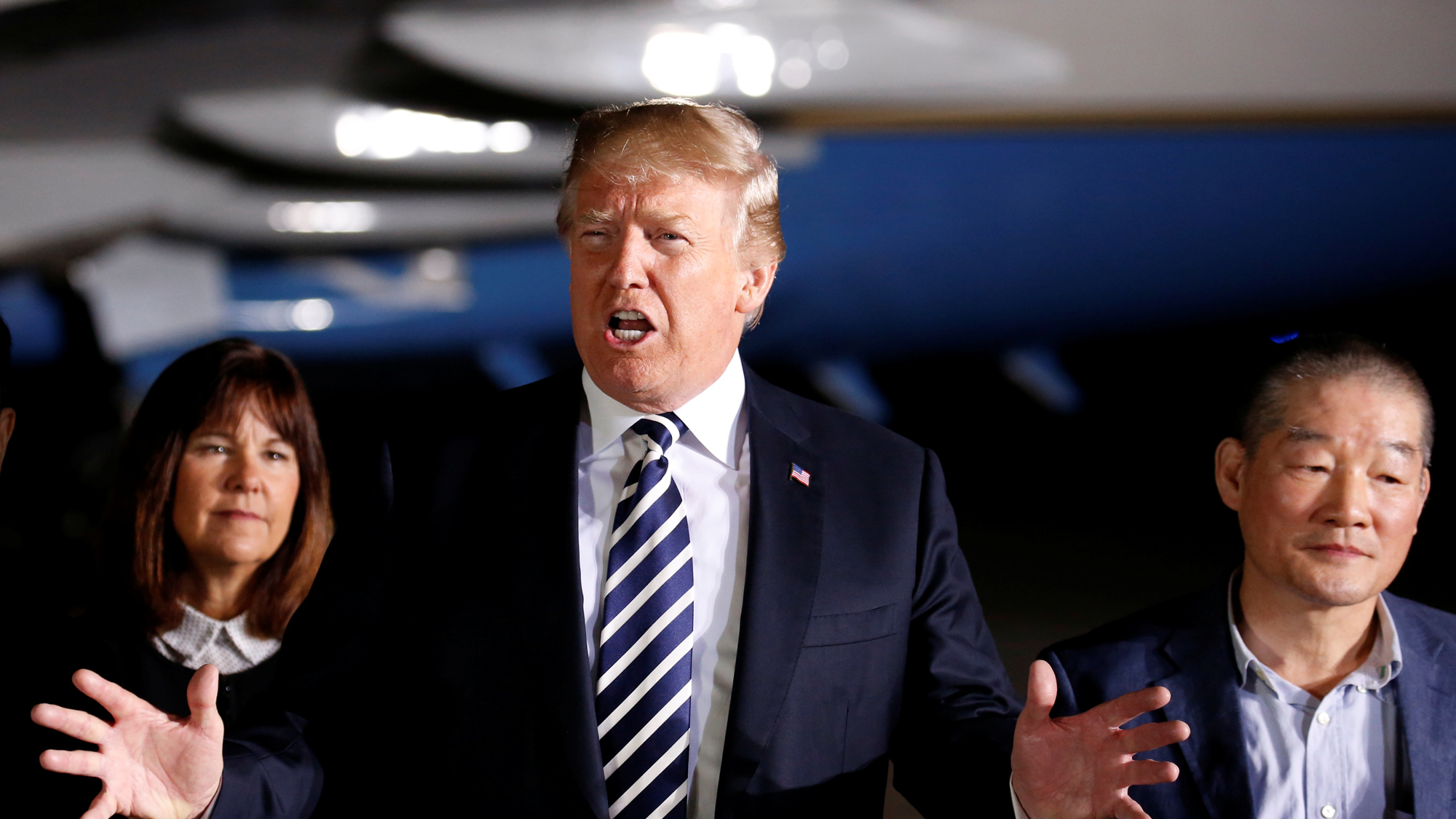 President Donald Trump talks to the media next with his hands outstretched on the tarmac at Joint Base Andrews, Maryland.