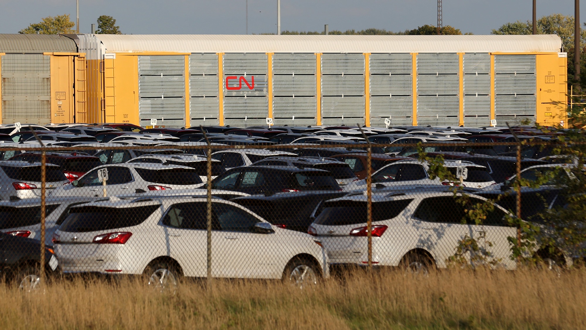 Chevrolet Equinox SUVs are parked awaiting shipment by CN Rail next to the General Motors CAMI assembly plant in Ingersoll, Ontario. Chevrolet Equinox SUVs are shown parked in a fenced in area with CN Rail cars in tbe background.
