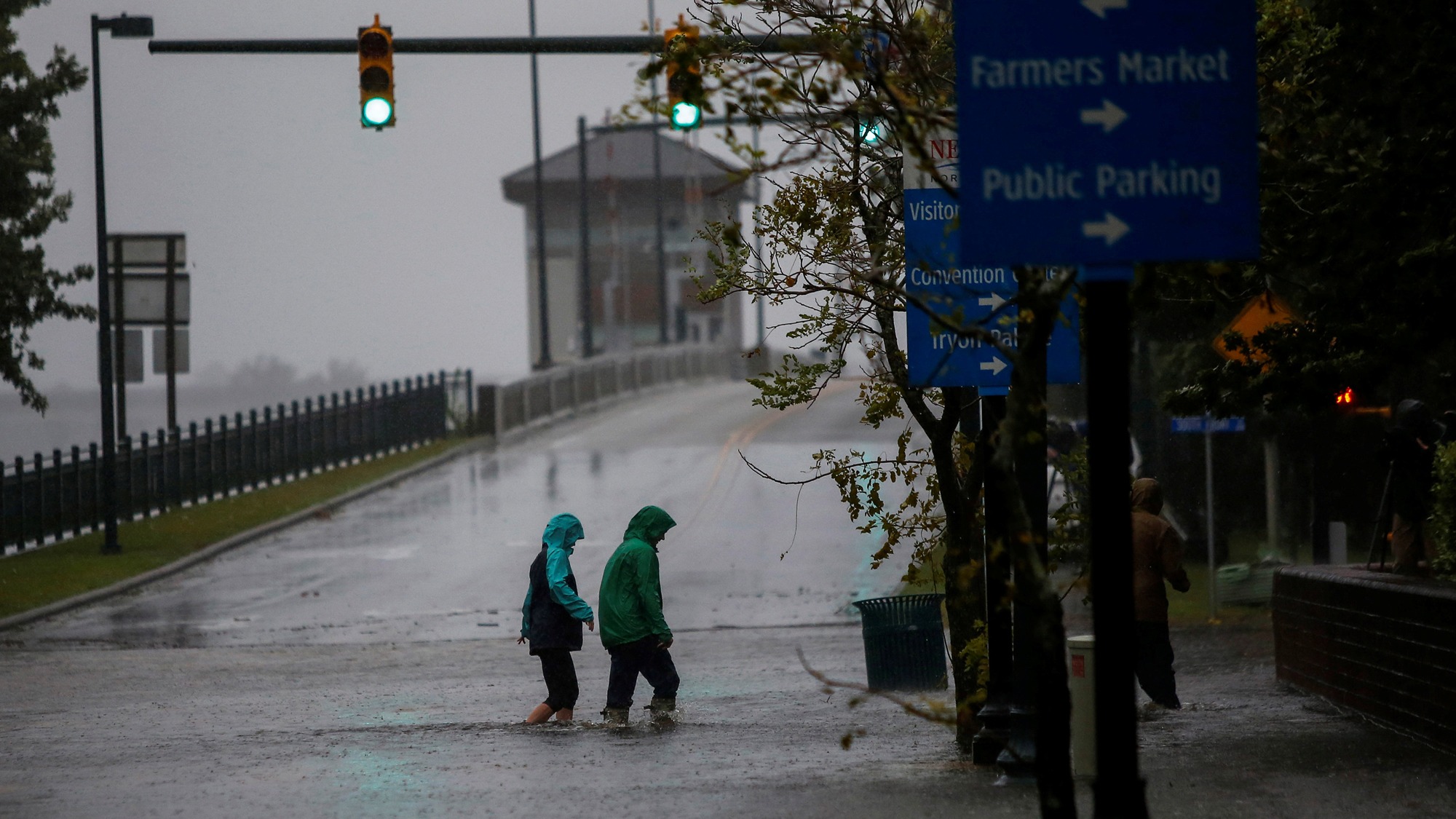 People walk on a local street as water from Neuse River starts flooding houses upon Hurricane Florence coming ashore in New Bern, North Carolina, Sept. 13, 2018. People are shown in rain jackets wading through a flooded street in New Bern, North Carolina, Sept. 13, 2018.