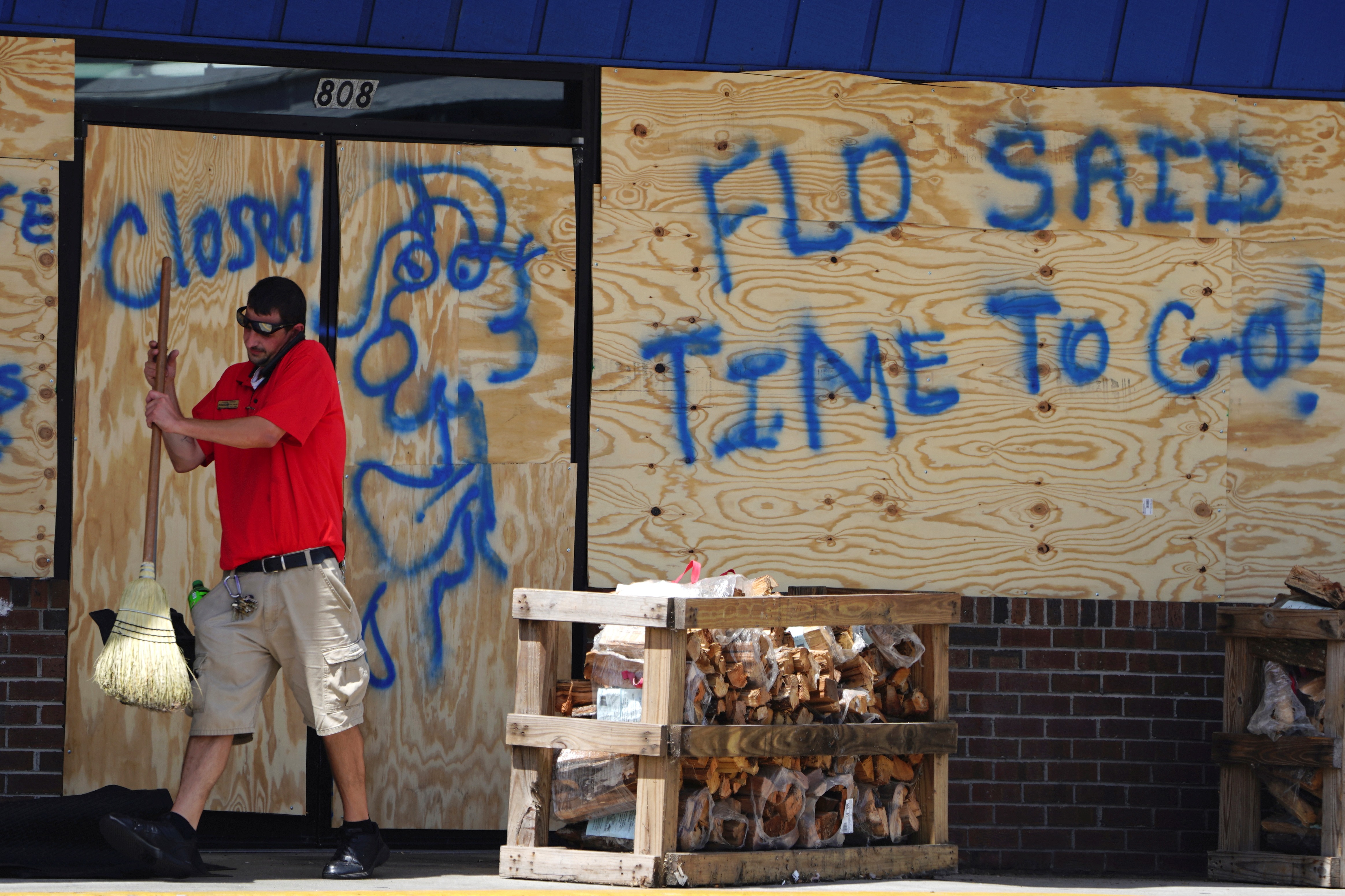 A man sweeps the entrance of a boarded up store before Hurricane Florence comes ashore in Carolina Beach, North Carolina, Wednesday A man sweeps the entrance of a boarded up store before Hurricane Florence comes ashore in Carolina Beach, North Carolina, Wednesday