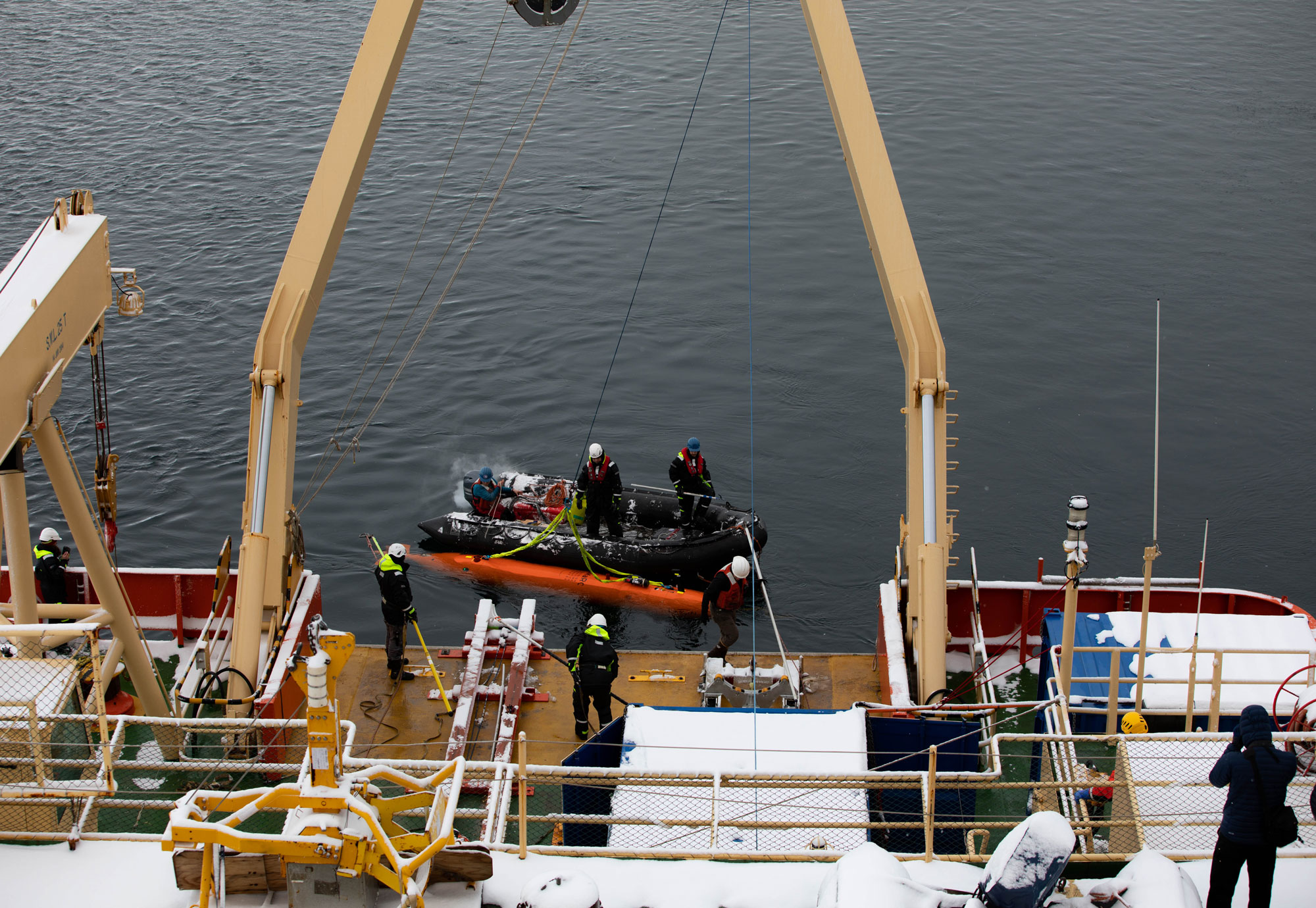 The Hugin sub gets tied to a winch cable and hoisted back on deck of the Nathaniel B. Palmer. The Hugin submarine is shown getting tied to a winch cable.