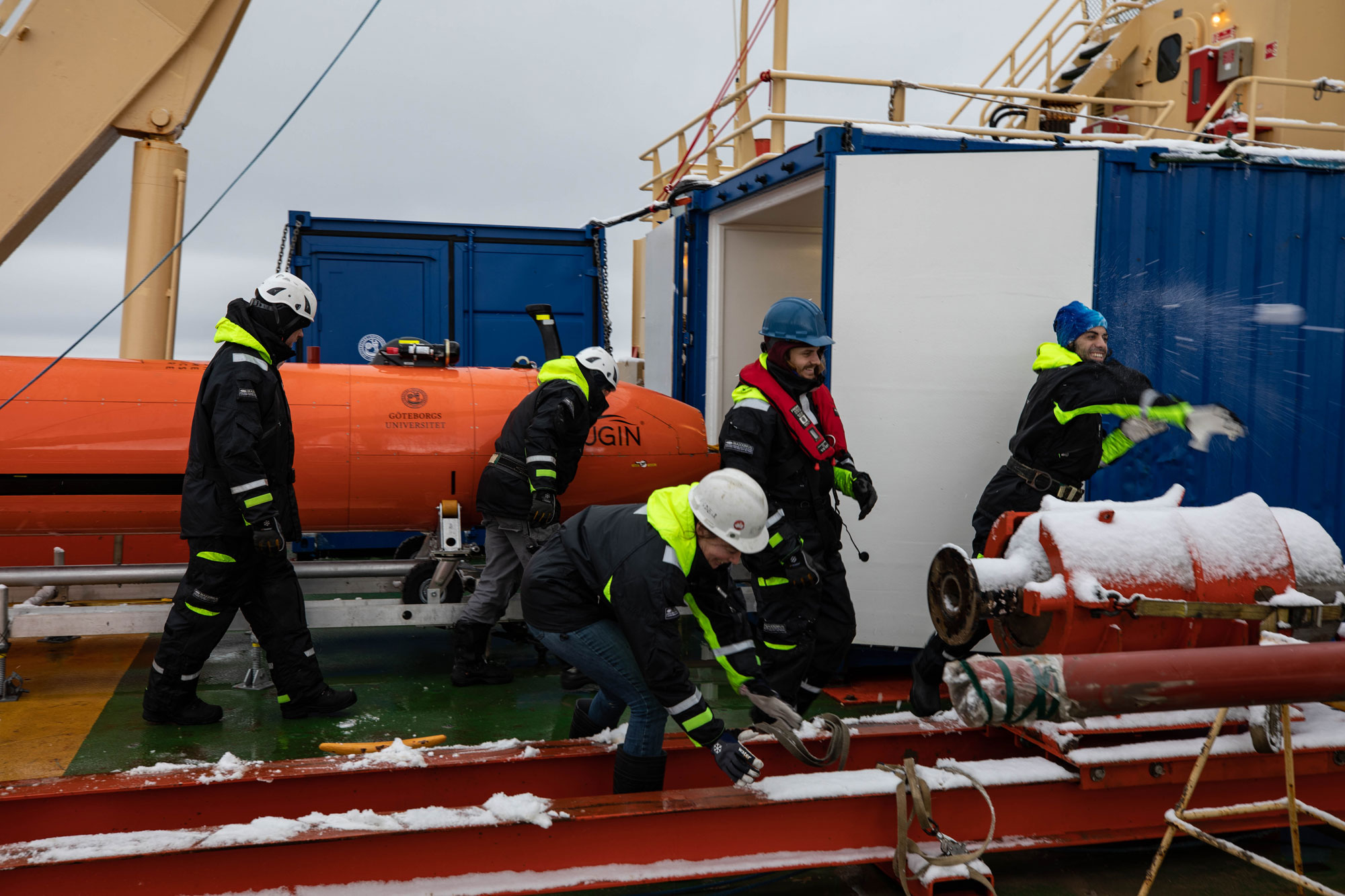 University of Gothenburg scientists have a celebratory snowball fight after the Hugin returns from its first mission near Thwaites Glacier on March 1, 2019. University of Gothenburg scientists are shown throwing snowballs.