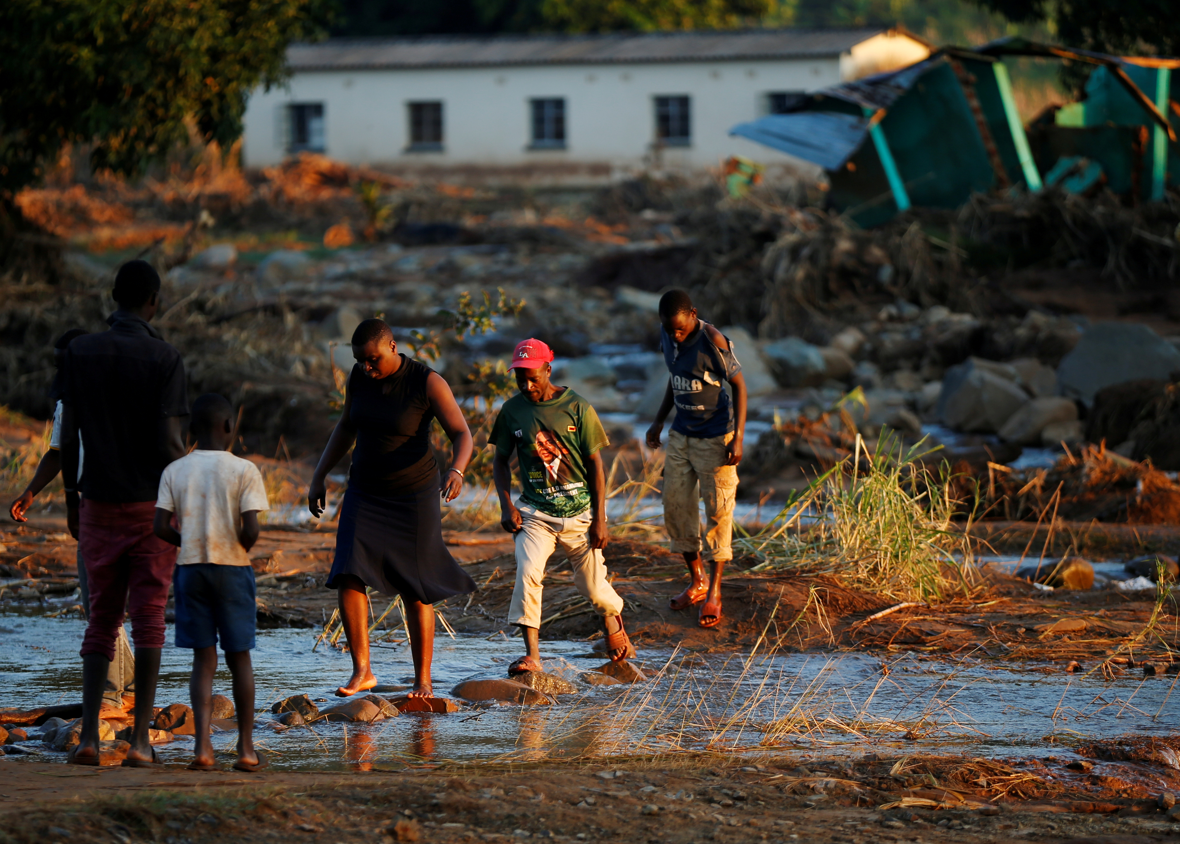 Survivors of Cyclone Idai walk through flooded waters to business center to receive aid.