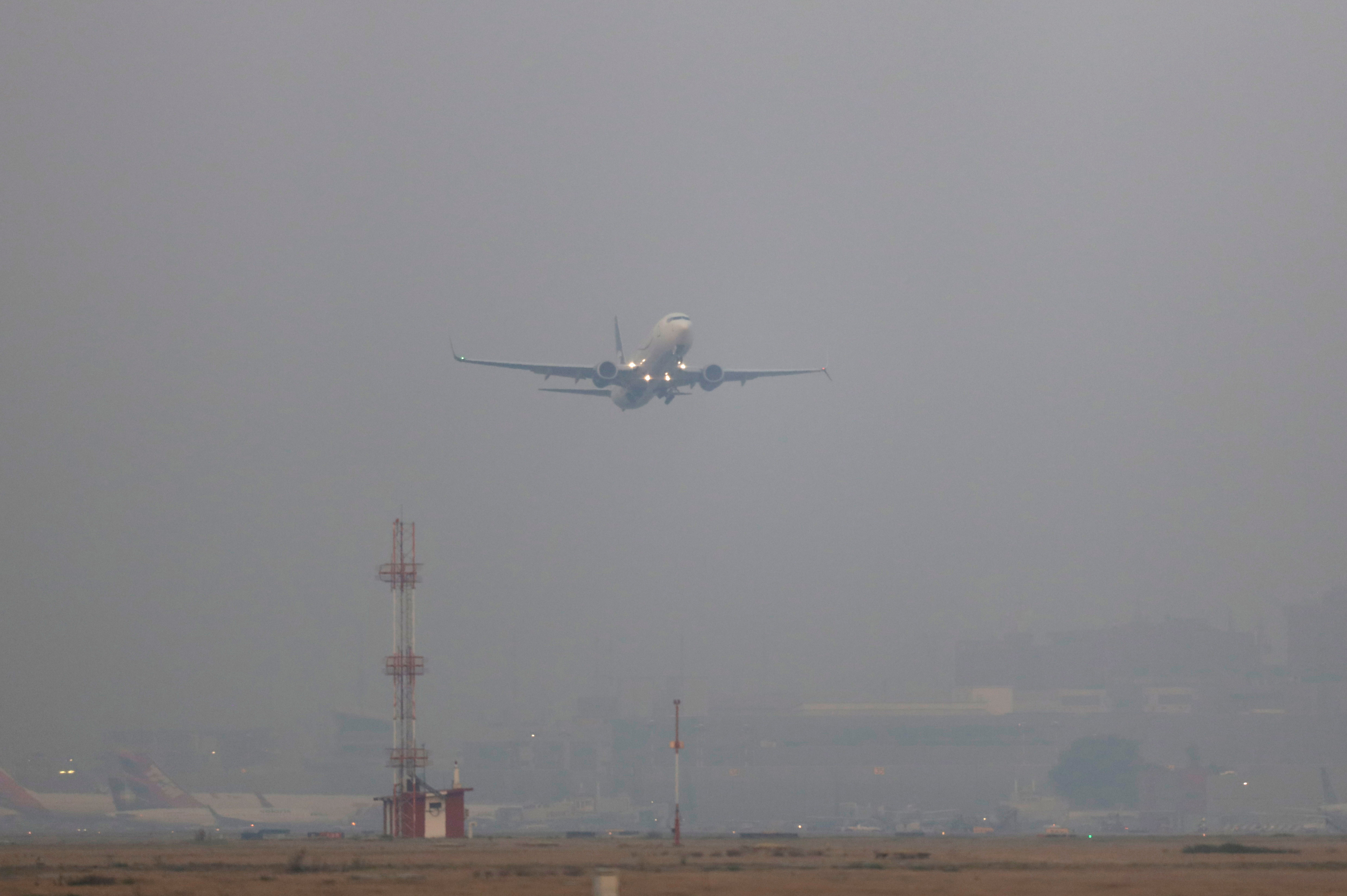 A plane takes off in smog