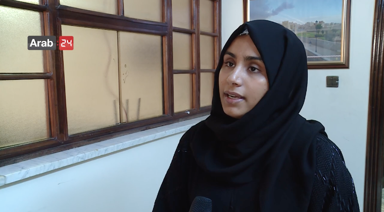 Woman wearing black hijab speaks to media