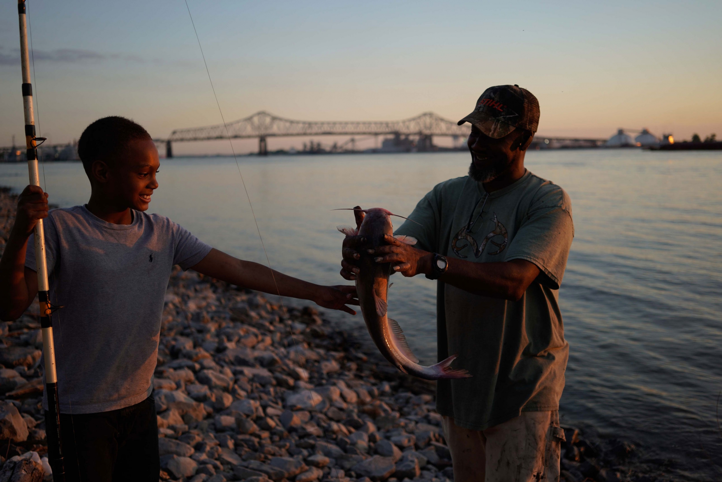 A fish is pulled from the Mississippi River near Baton Rouge, Louisiana. A man is shown with a large fish next to a younger boy.