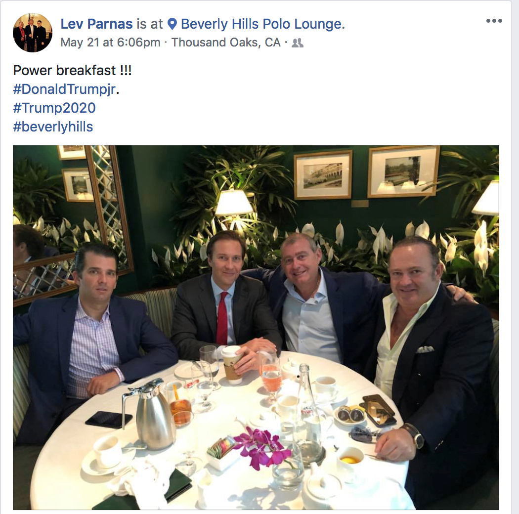 Men in suits sit around a table.