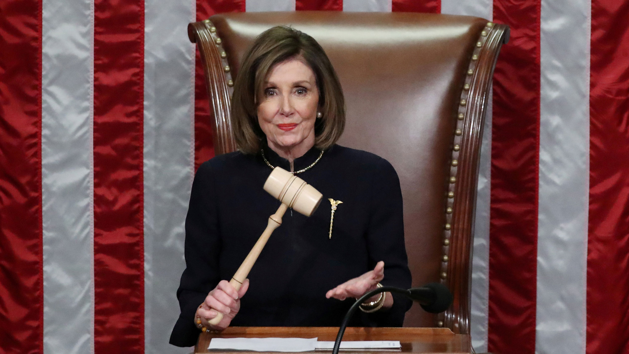 US Speaker of the House Nancy Pelosi wields the gavel as she presides over the House of Representatives approving two counts of impeachment against President Donald Trump in Washington DC, Dec. 18, 2019. US Speaker of the House Nancy Pelosi wields the gavel and stands in front of a large US flag.
