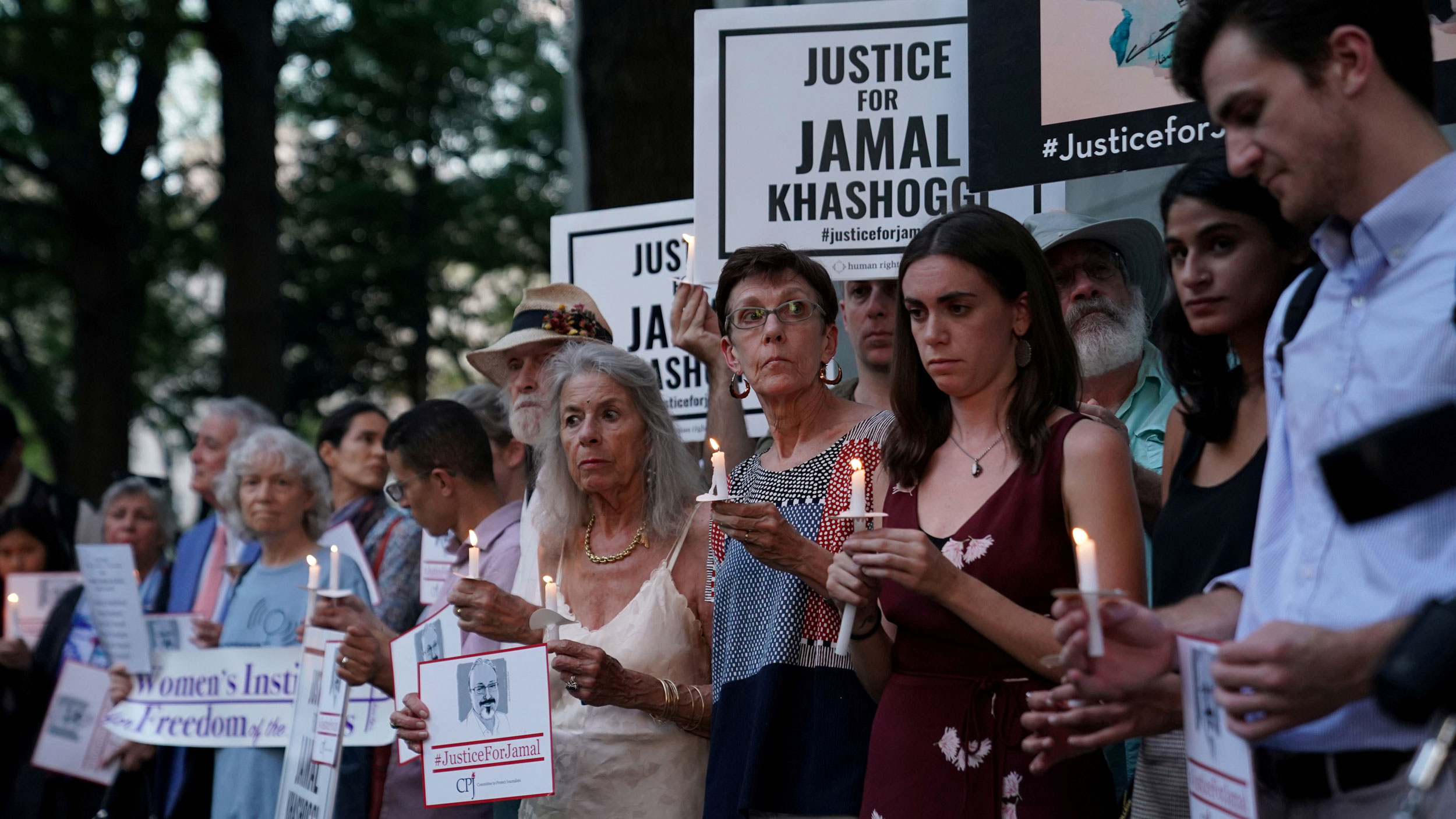 The Committee to Protect Journalists and other press freedom activists hold a candlelight vigil in front of the Saudi Embassy in Washington, DC, Oct. 2, 2019, marking the anniversary of the killing of journalist Jamal Khashoggi in Istanbul. A large group of people are shown, many with burning candles, and others holding signs that that read, "Justice of Jamal Khashoggi."