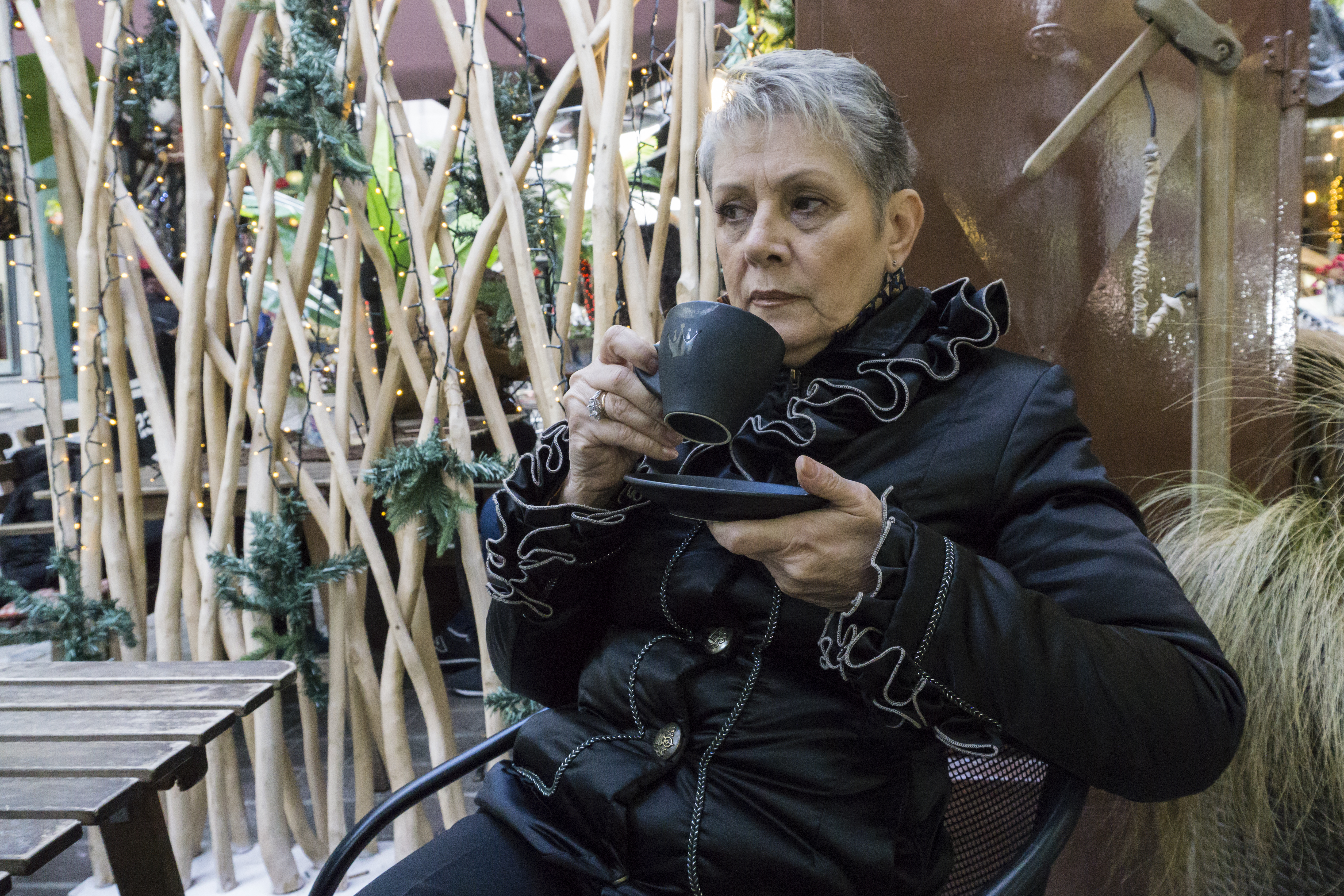 Avrilia Kosmaidou planned a cremation for her best friend and had to go to Sofia, Bulgaria, before the first and only crematorium in Greece opened. Avrilia Kosmaidou sits and sips from a cup wearing a black jacket