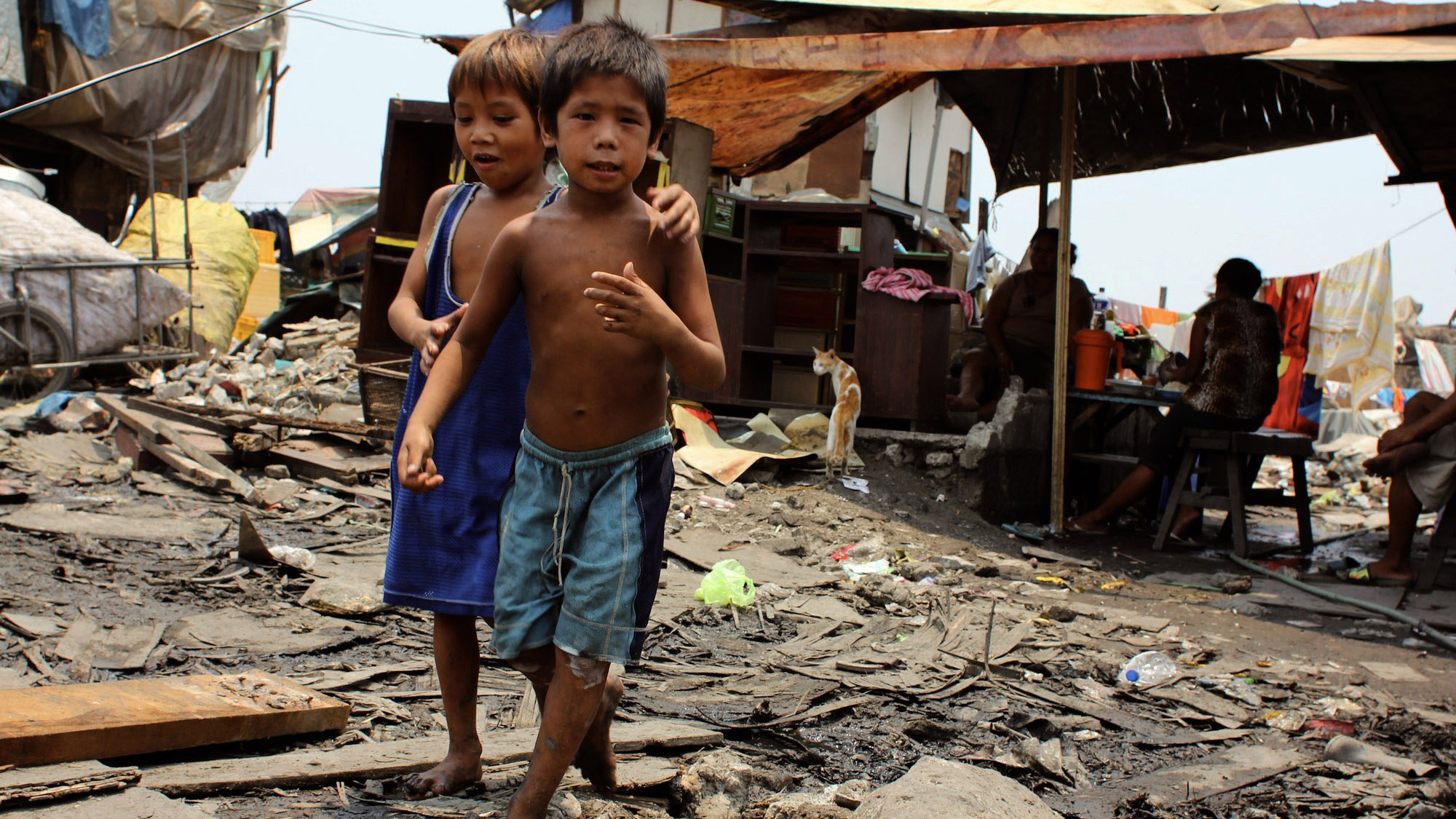 Children play in the streets of Sitio Damayan, where Ana Lisa Loste moved after Smokey Mountain, when the garbage dump where she was raised was shut down by the government. This area, which smells of rotting trash from the junk shops down the road, is wid Children play in the streets of Sitio Damayan, where Ana Lisa Loste moved after Smokey Mountain, when the garbage dump where she was raised was shut down by the government. This area, which smells of rotting trash from the junk shops down the road, is wid
