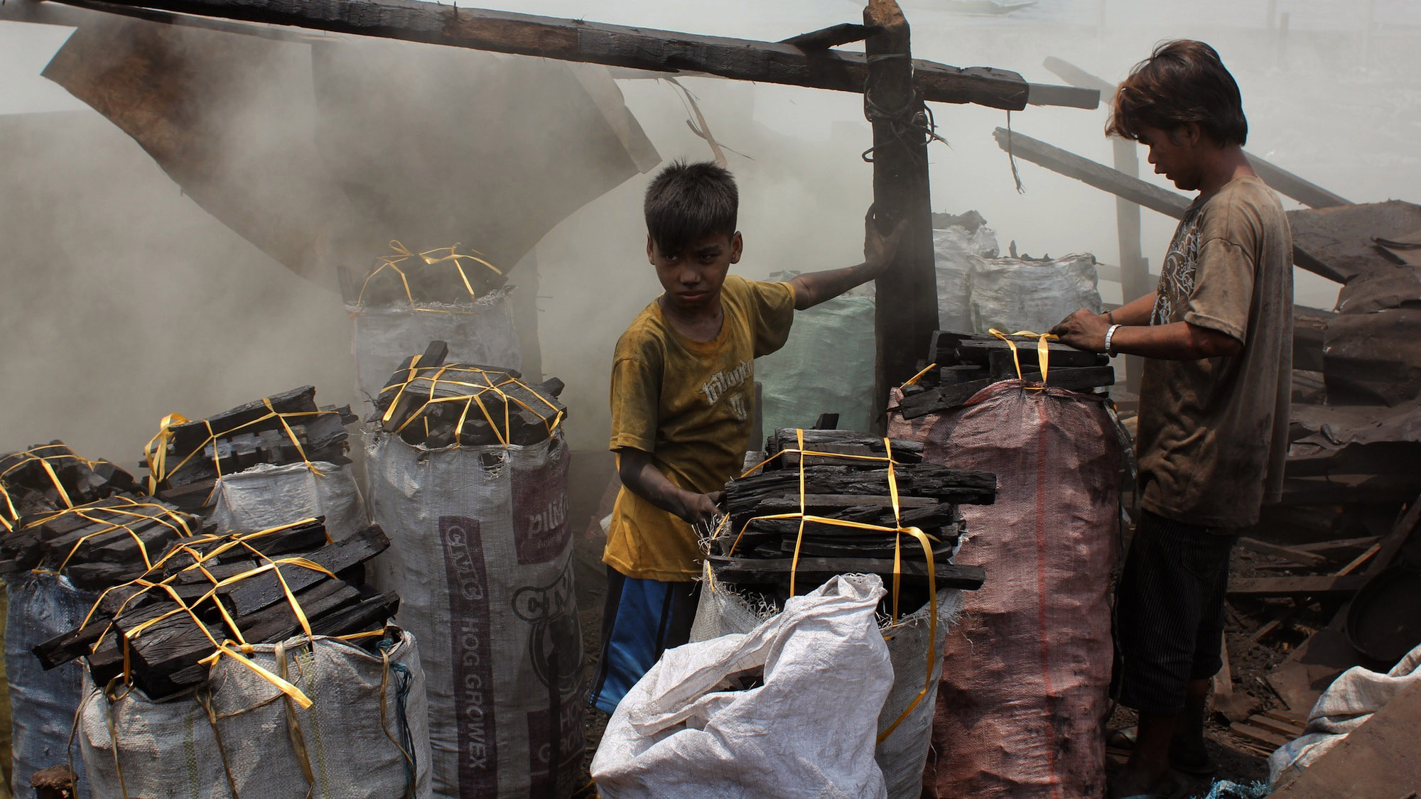 Ana Lisa Loste lives near the part of the slum called ulingan, where crude charcoal kilns burn all day, filling the air with stinging smoke. Children and young men work packing and curing the charcoal. Ana Lisa Loste lives near the part of the slum called ulingan, where crude charcoal kilns burn all day, filling the air with stinging smoke. Children and young men work packing and curing the charcoal.