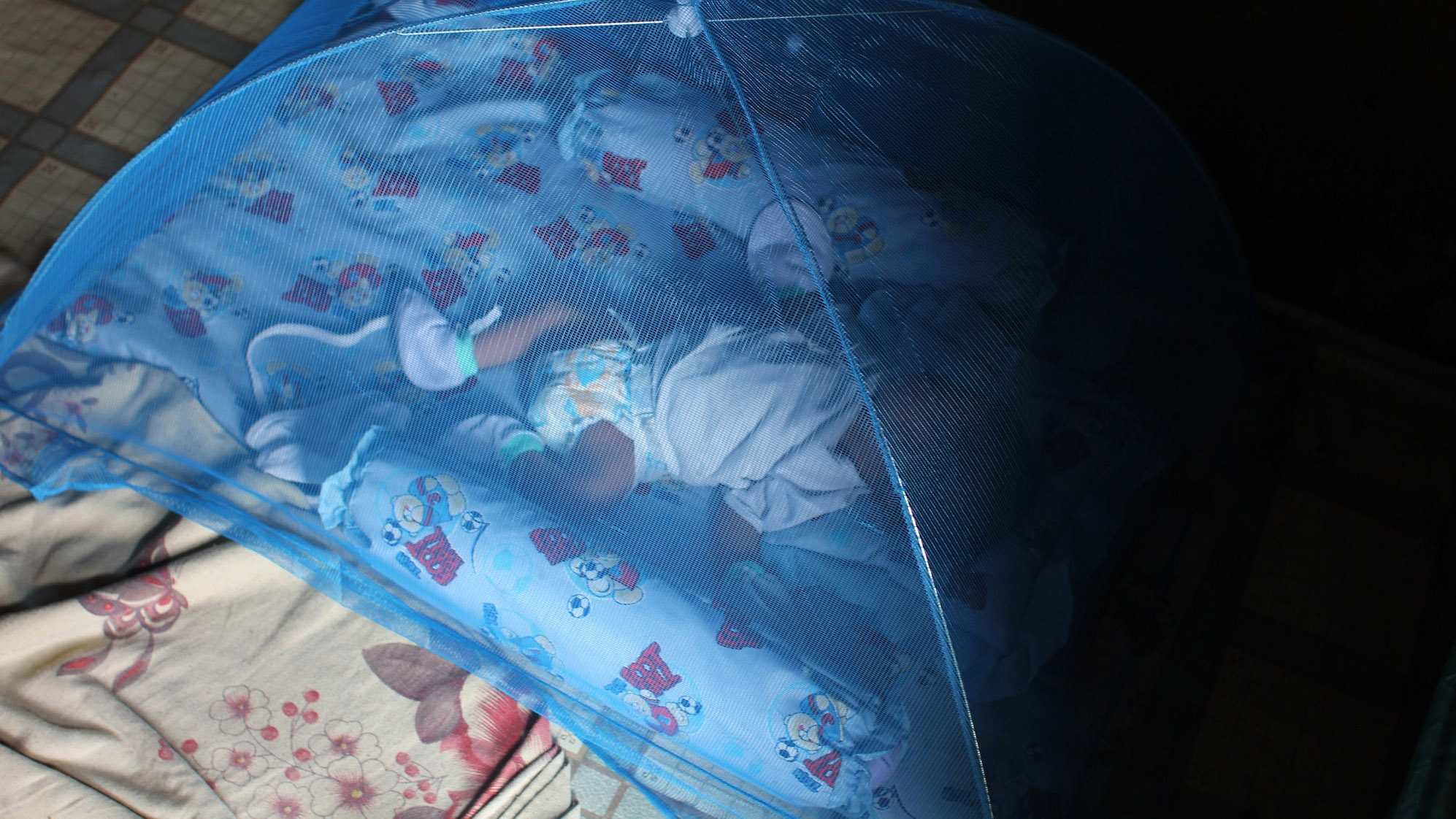 Loste’s grandson sleeps under a mosquito net on the floor of their one-room shack in the slum of Tondo in Manila. Loste’s grandson sleeps under a mosquito net on the floor of their one-room shack in the slum of Tondo in Manila.
