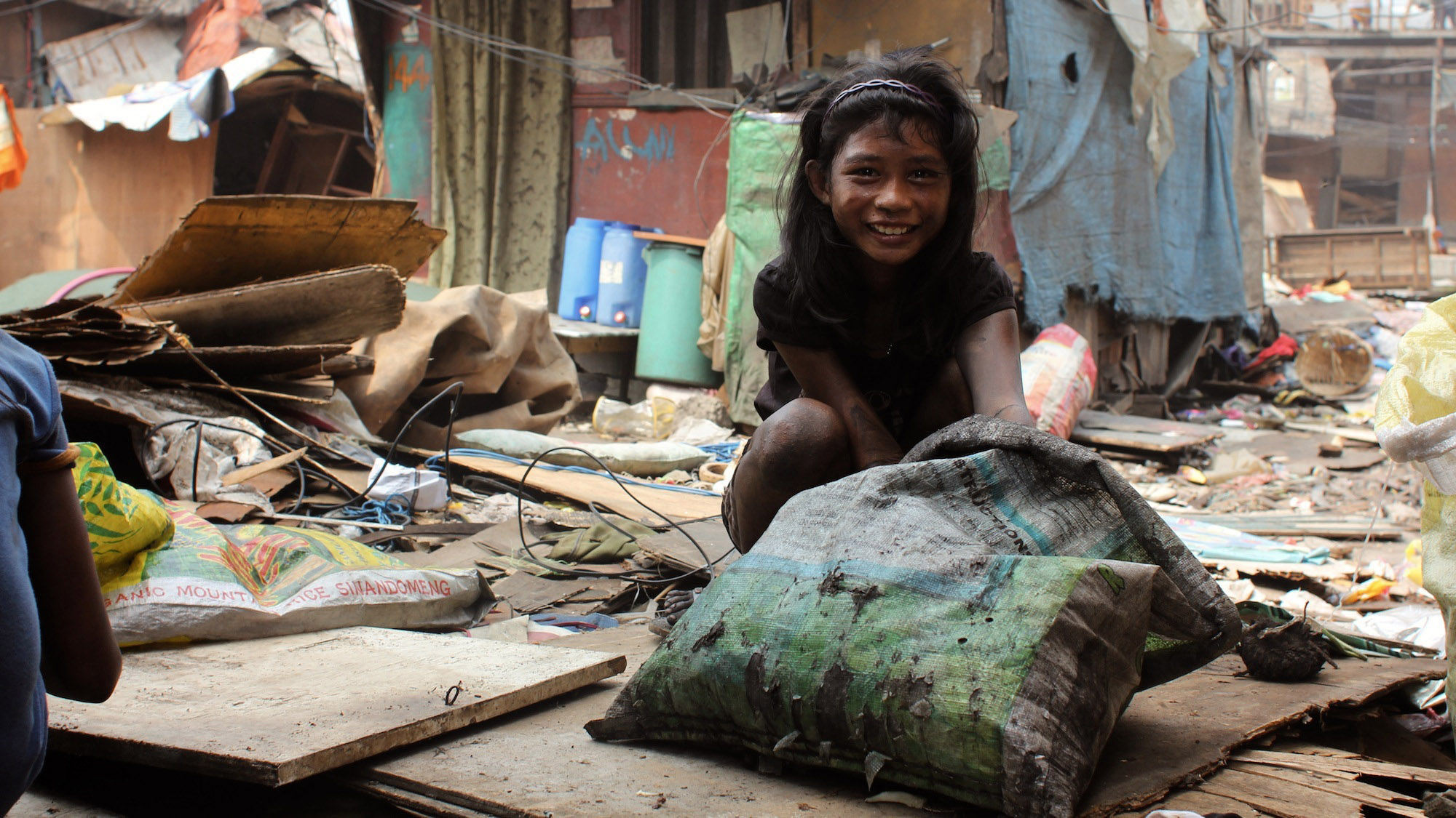 A young girl that lives in the shack next to Loste is covered in soot from hauling charcoal. A young girl that lives in the shack next to Loste is covered in soot from hauling charcoal.