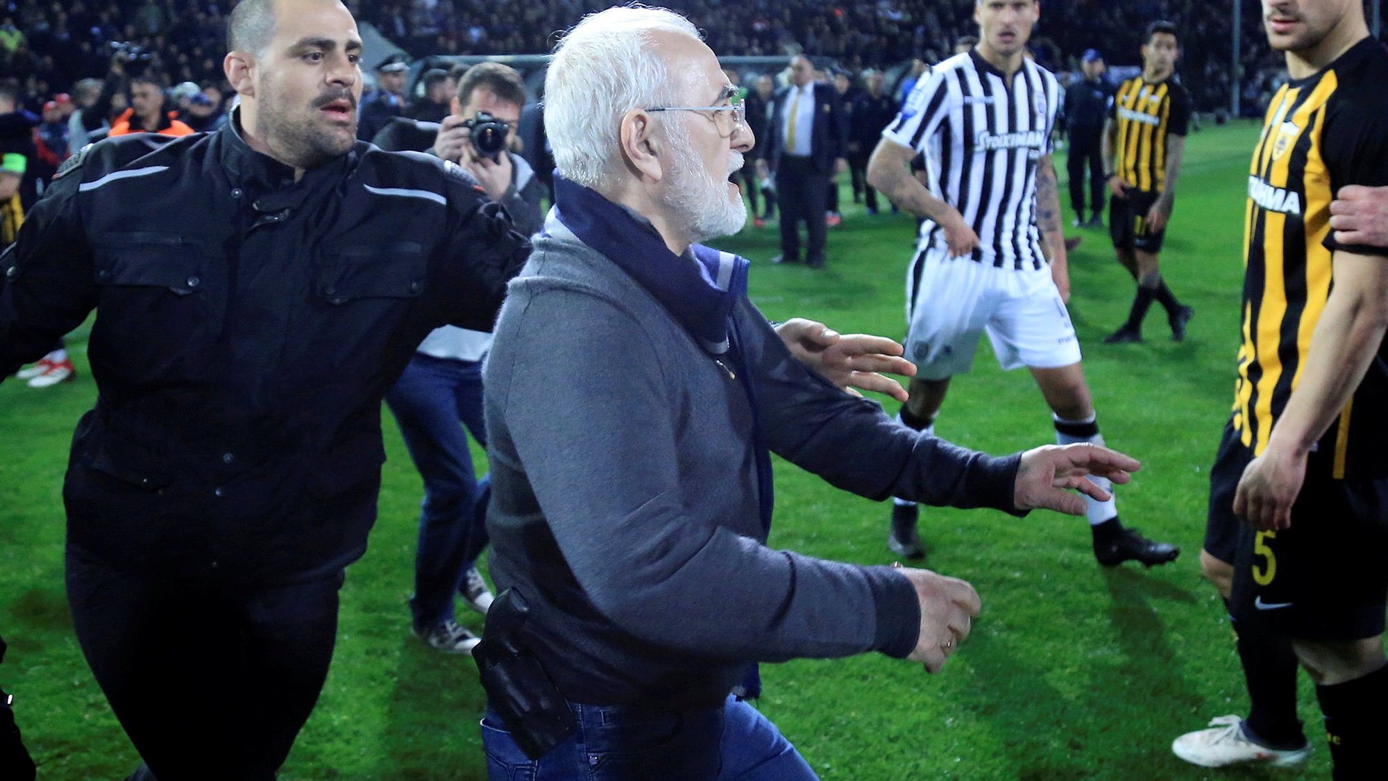 Russian-born Greek businessman and owner of PAOK Salonika, Ivan Savvides (C), pictured with what appears to be a gun in a holster, enters the field after the referee annulled a goal of PAOK during their soccer match against AEK Athens in Toumba Stadium in van Savvides is pictured with what appears to be a gun in a holster as he rushes on to the soccer field in Greece.