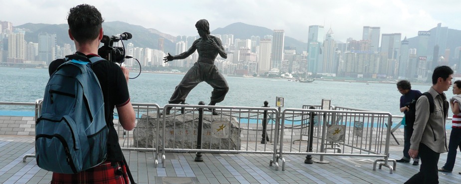 Filmmaker Mark Cousins during this six-year filming of The Story of Film, shooting the skyline of Hong Kong with a statue of hometown hero and martial artist Bruce Lee in the foreground. Filmmaker Mark Cousins during this six-year filming of The Story of Film, shooting the skyline of Hong Kong with a statue of hometown hero and martial artist Bruce Lee in the foreground.