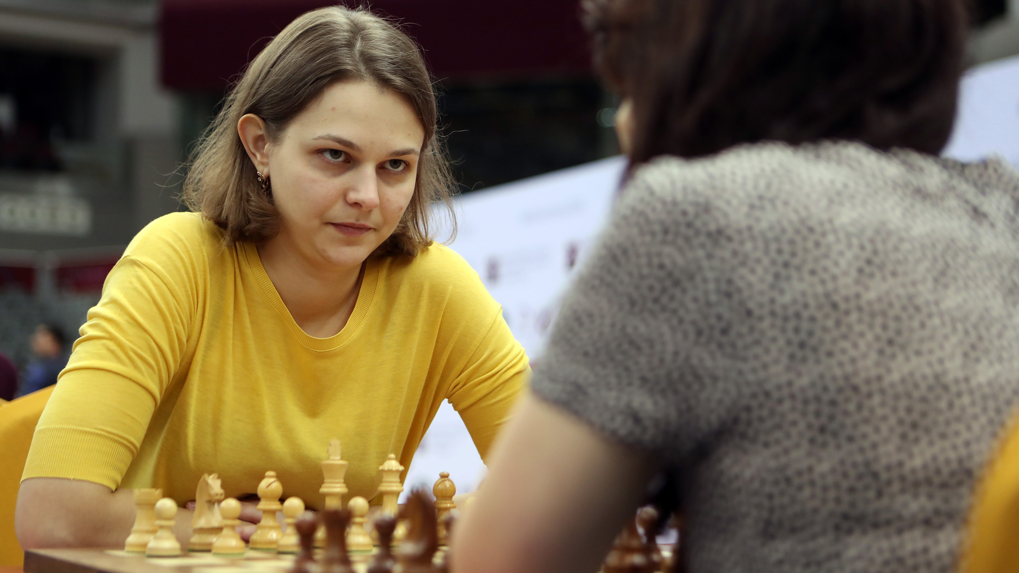 Ukraine's grandmaster Anna Muzychuk plays during the FIDE World Chess Rapid & Blitz Championships 2016, in Doha, Qatar. Ukraine's grandmaster Anna Muzychuk, wearing a yellow shirt, stares down her opponent across a chess board.