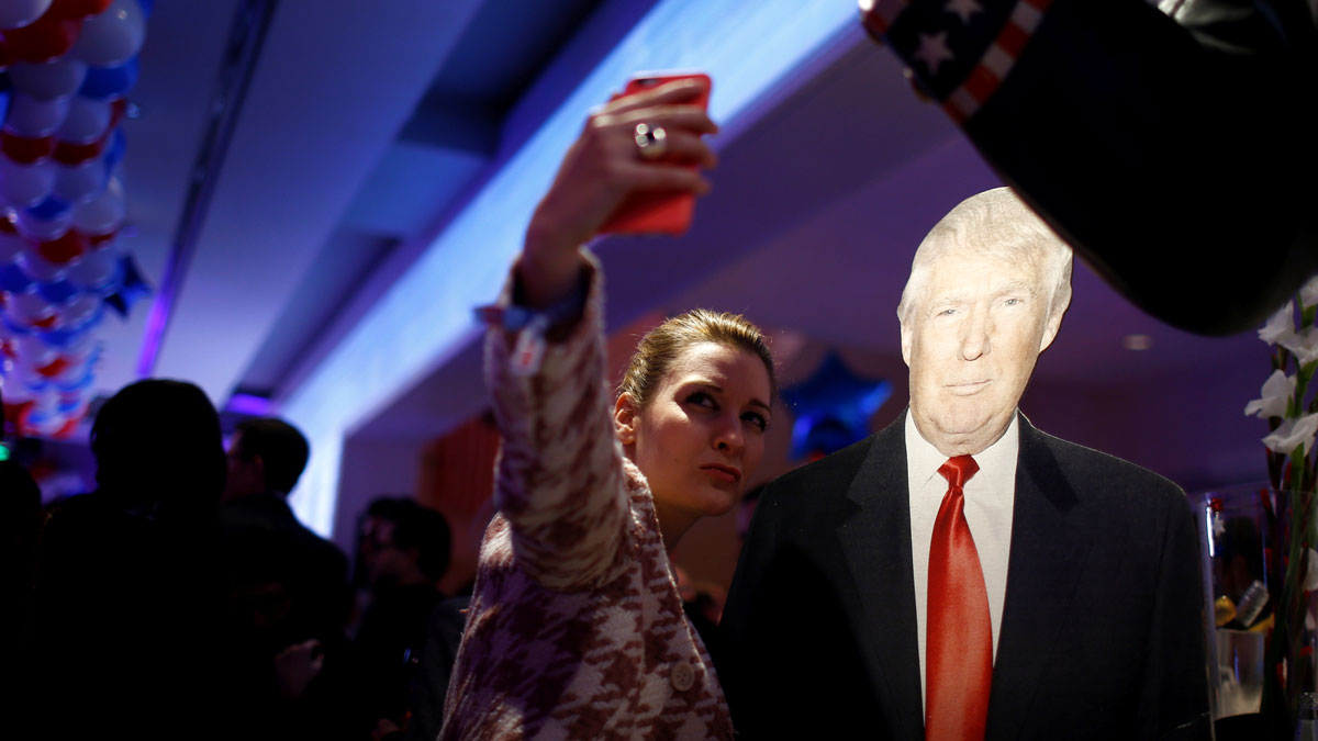 A woman photographs herself with a cardboard figure of US Republican presidential candidate Donald Trump in Berlin, Germany, Tuesday night. A woman photographs herself with a cardboard figure of U.S. Republican presidential candidate Donald Trump in Berlin, Germany, November 8, 2016. REUTERS/Axel Schmidt