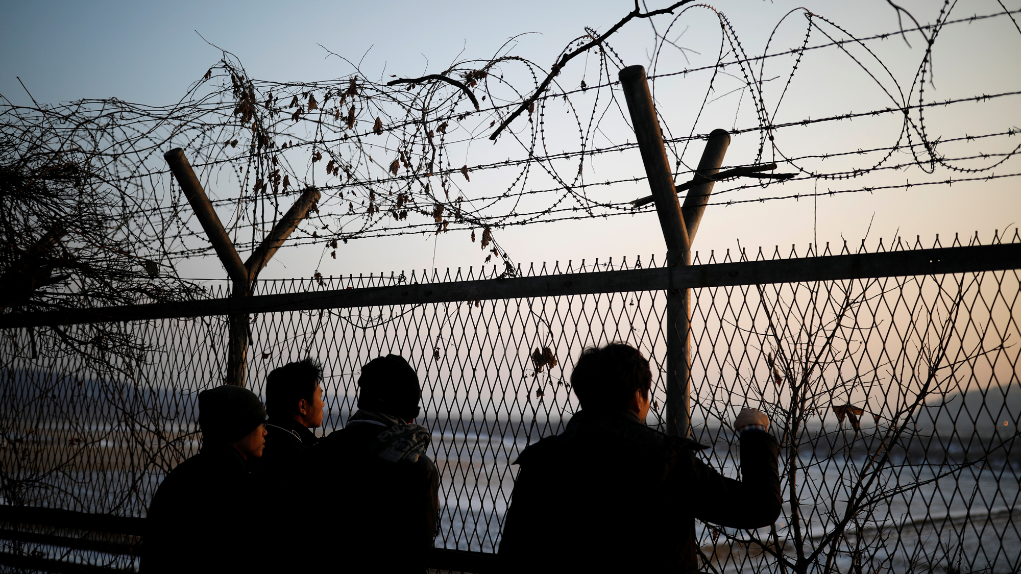 People look toward the north through a barbed-wire fence near the demilitarized zone separating the two Koreas, in Paju, South Korea. People look toward the north through a barbed-wire fence near the demilitarized zone separating the two Koreas, in Paju, South Korea.