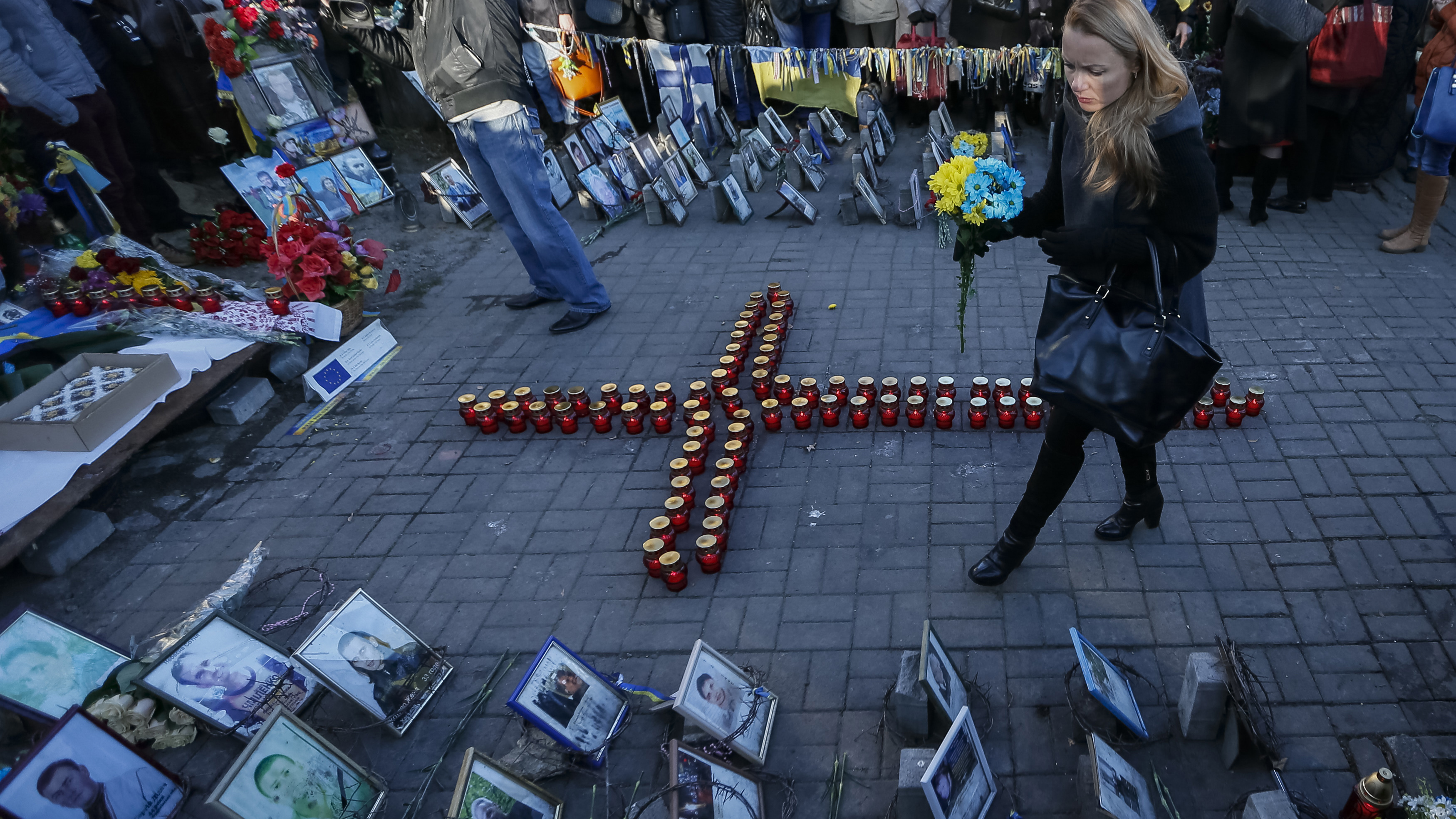 A woman walks near a memorial to those who died protesting against President Yanukovych, during a commemoration ceremony for them in Kiev Friday, as Ukrainians marked the first anniversary of protests which led to the revolution. A woman walks near a memorial to those who died protesting against President Yanukovych, during a commemoration ceremony for them in Kiev Friday, as Ukrainians marked the first anniversary of protests which led to the revolution.