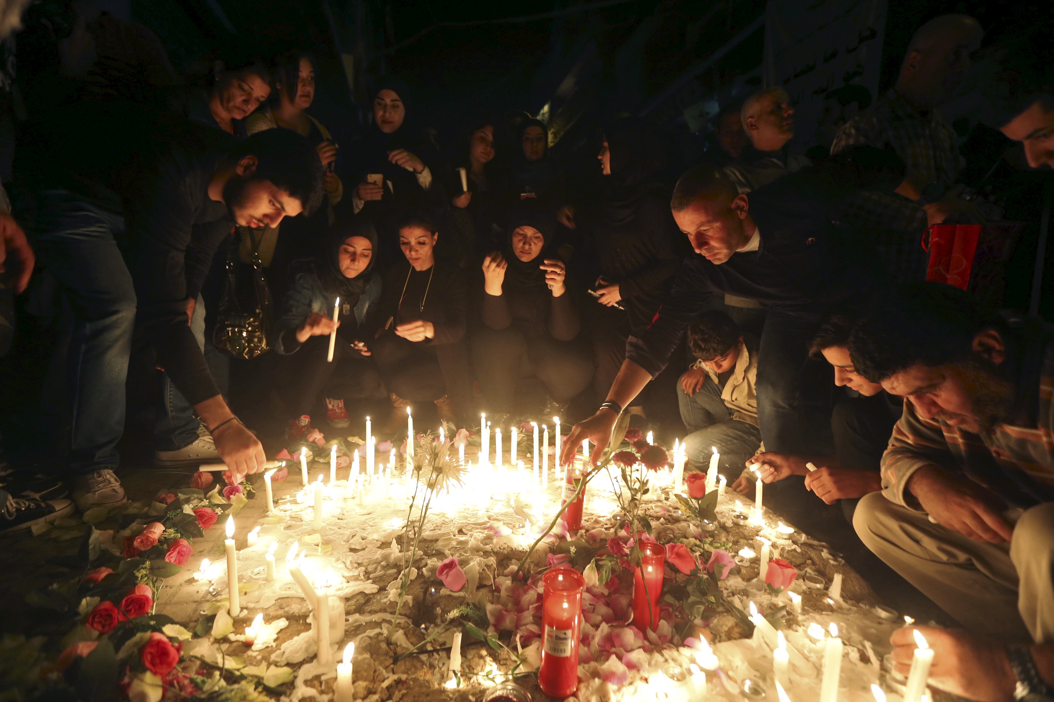 Beirut residents light candles during a vigil at the site of the two explosions that occurred on Thursday in the southern suburbs of the Lebanese capital Beirut, Beirut residents light candles during a vigil at the site of the two explosions that occurred on Thursday in the southern suburbs of the Lebanese capital Beirut,