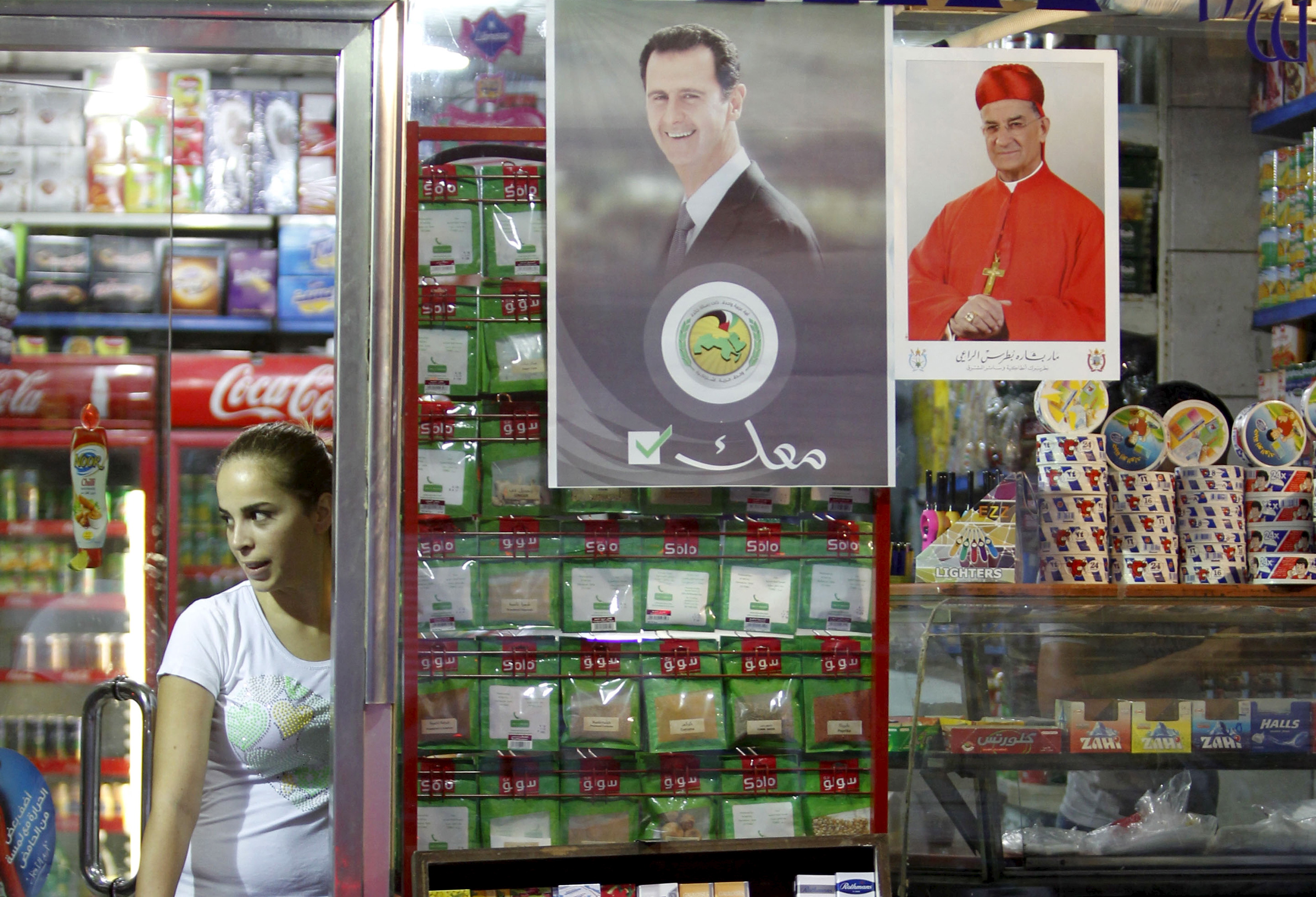 A Woman Stands Inside A Damascus Grocery Shop Beside A Picture Of Syria S President Bashar Al Assad The Text Beneath The Syrian Leader Reads With You In Arabic The World From Prx