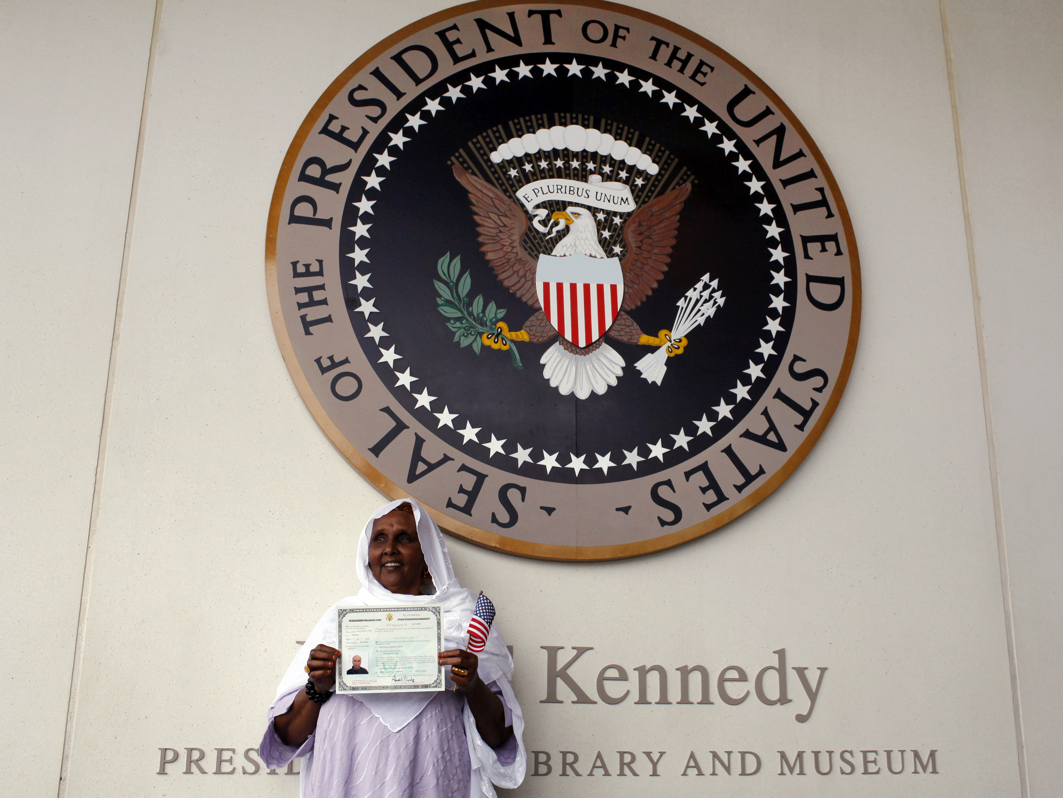 A woman holds up her certificate of U.S. citizenship A woman holds up her certificate of U.S. citizenship