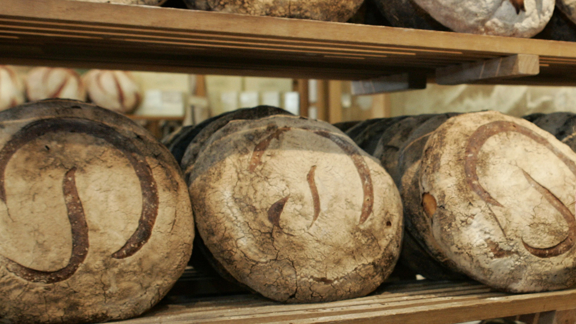 Freshly baked Miche line the walls at the original Poilane family bread bakery in Paris. Freshly baked Miche line the walls at the original Poilane family bread bakery in Paris.