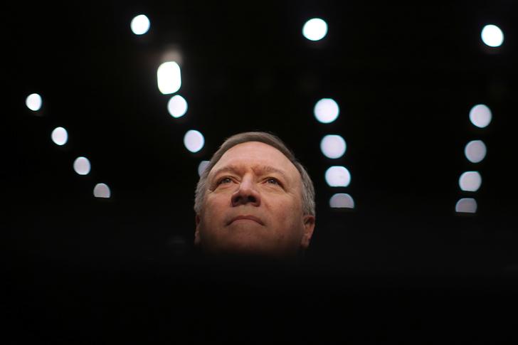 Portrait of man's head against rows of lights, dark around him