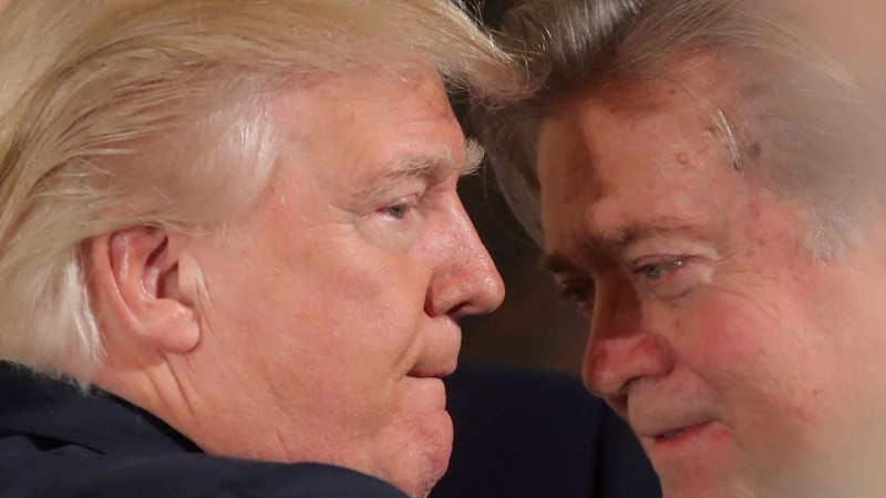 President Donald Trump talks to chief strategist Steve Bannon during a swearing in ceremony for senior staff at the White House in Washington, Jan. 22, 2017.