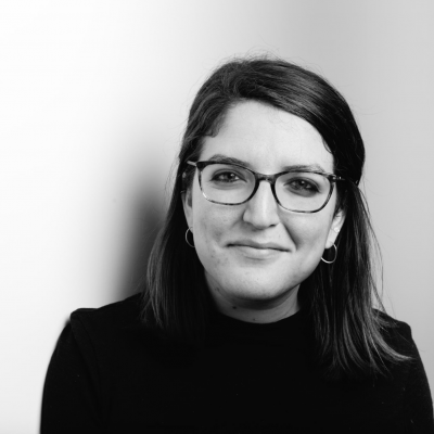 Anna Kusmer A woman wearing a dark sweater and glasses looks at the camera.