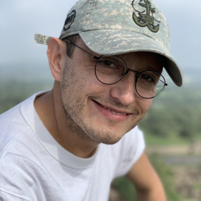 Jorge Valencia A man who is wearing a grey cap smiles at the camera.