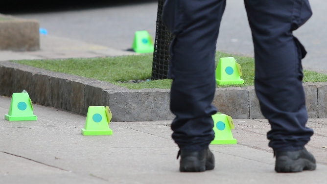 A police officer stands near evidence markers while investigating a mass shooting on Danforth Avenue in Toronto, Canada. A police officer stands near evidence markers while investigating a mass shooting on Danforth Avenue in Toronto, Canada.