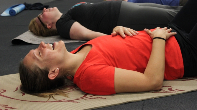 A woman smiling at a laughter yoga class