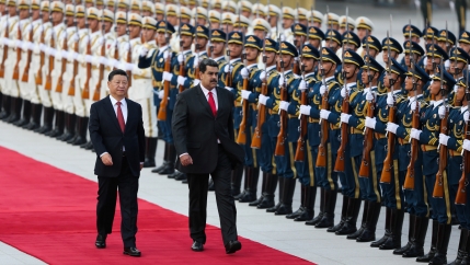 Chinese President Xi Jinping walks next to Venezuela's President Nicolas Maduro in front of a row of Chinese troops