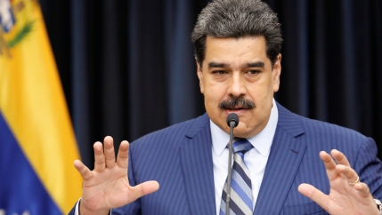 Venezuela President Maduro in blue suit holds his hands out and speaks at news conference. 