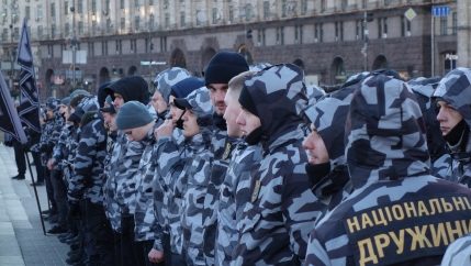 Men wear grey and black military fatigues. 