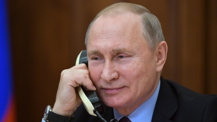a smiling vladimir putin on the phone