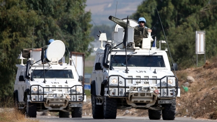 Soldiers in white tanks on a road