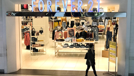 A woman walks in front of the store Forever 21.
