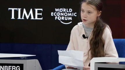 Greta Thunberg sits at the World Economic Forum. 