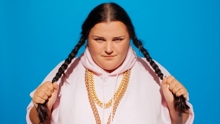 A woman with braids in a pink track sweatshirt