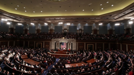 US President Donald Trump is shown standing at a podium at the center of a joint session of Congress.