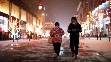 People wearing face masks walk along a street, as China is hit by an outbreak of the new coronavirus, in Beijing, Feb. 5, 2020. 