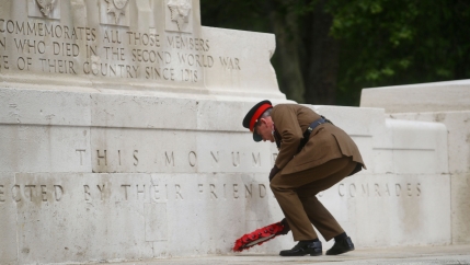 A officer lays a poppy wreath