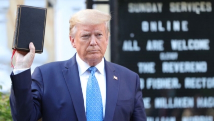 President Trump holds up a Bible. 
